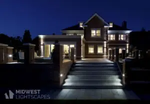 Illuminated brick home with uplights, path lights along stairs and walkway | Midwest Lightscapes, Kankakee, Illinois