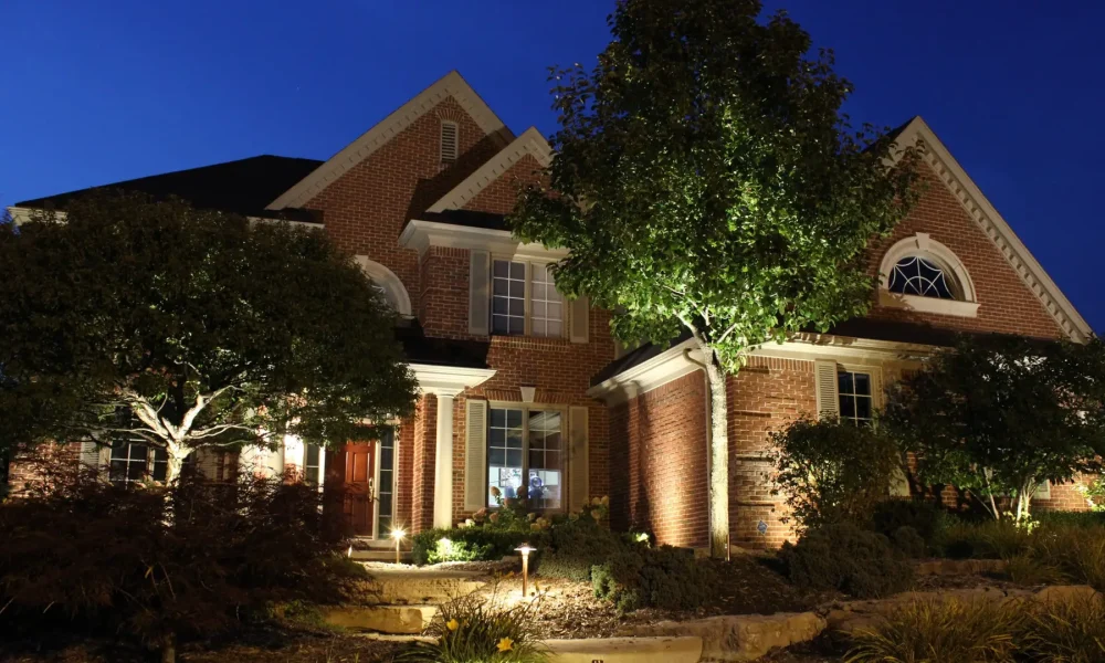 Illuminated brick home with uplights and illuminated landscape | Midwest Lightscapes, Kankakee, Illinois